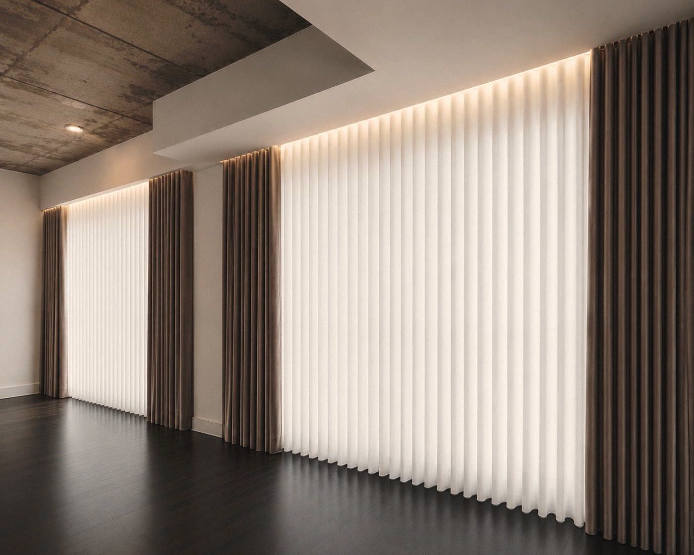 Des rideaux du plancher au plafond, aux plis profonds, sur toute la longueur d’une pièce.